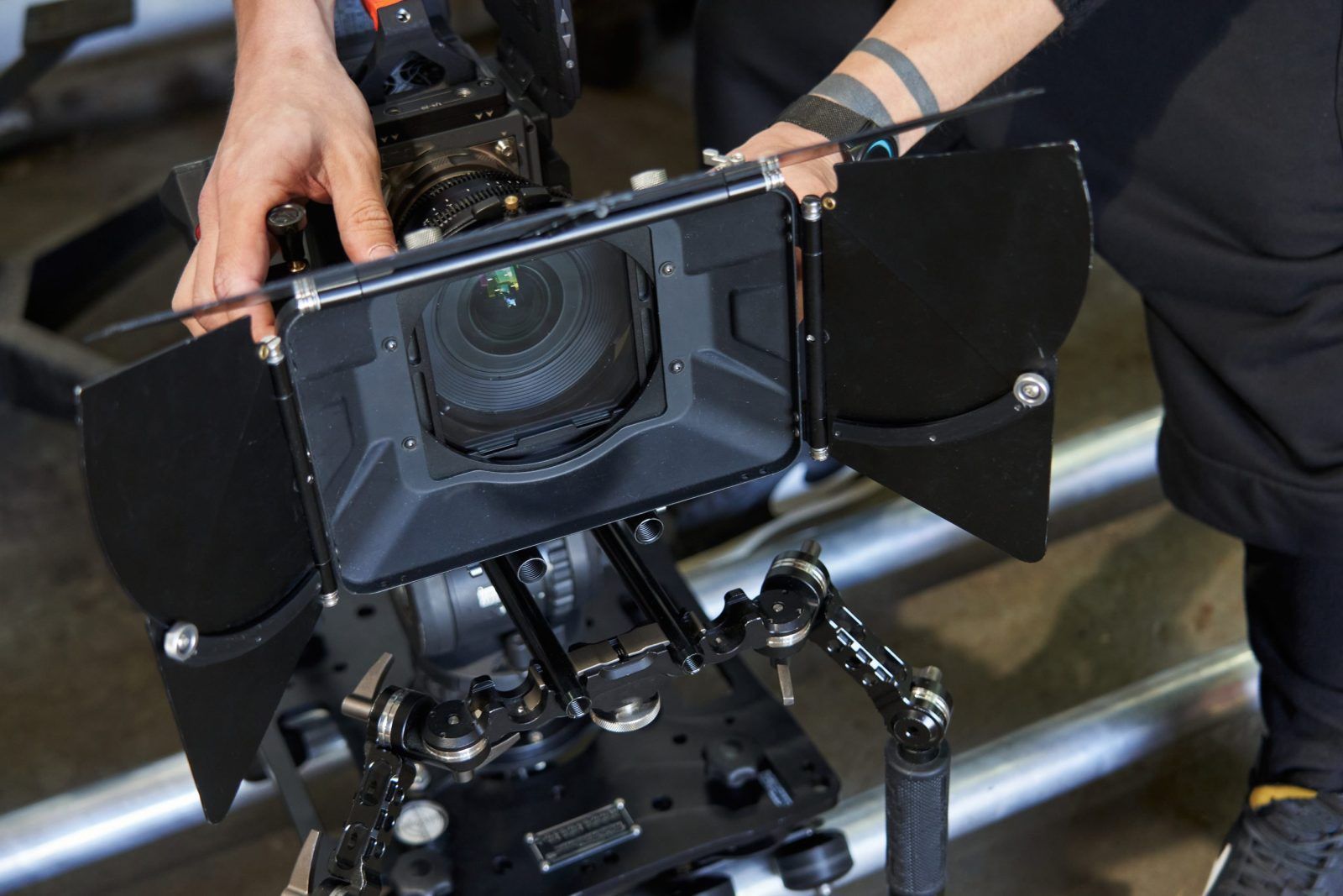 Two serious men in black sweatshirta discussing settings of steadicam